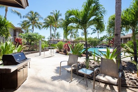 Shaded patio with seating and BBQ grill steps from the pool
