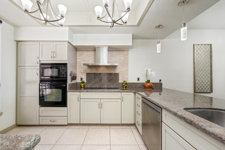 Well equipped kitchen with modern appliances and granite countertops