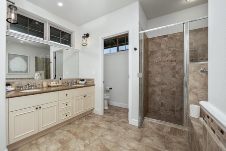 Your private retreat features a spacious bathroom with elegant stone tile, dual vanities, and a luxurious walk-in shower perfect for unwinding.