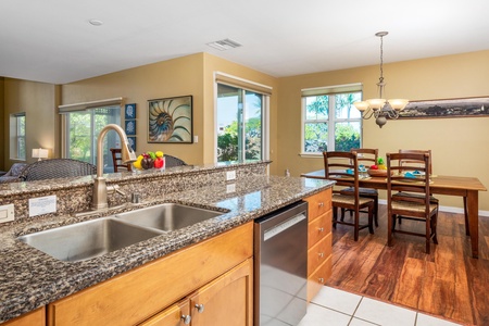 You'll love how this open kitchen flows into your dining and living spaces, with granite counters, a full dishwasher, and leafy views through every window—perfect for easy vacation meals and togetherness.