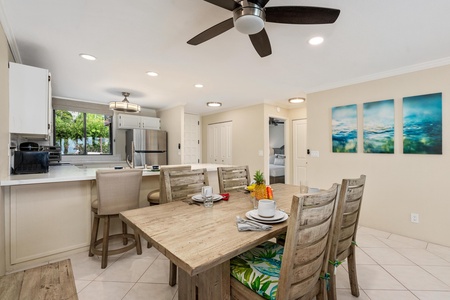 - Gather around the rustic wood dining table with tropical seat cushions for meals - Overhead fans and soft lighting keep the space breezy and inviting all day - Convenient layout connects dining to the kitchen and living areas with ease
