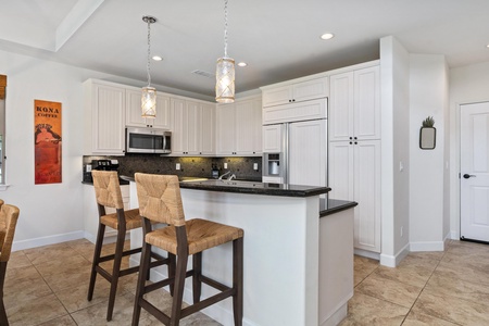 Full kitchen with breakfast bar, granite counters, and modern appliances