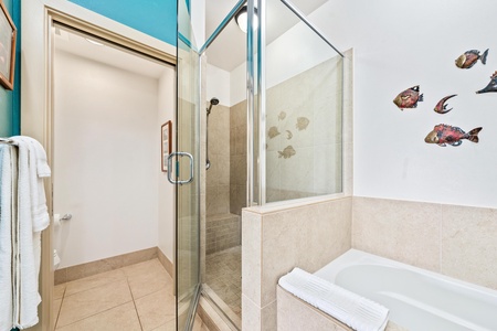 Ensuite primary bathroom with double vanity, walk-in shoer, and soaking tub