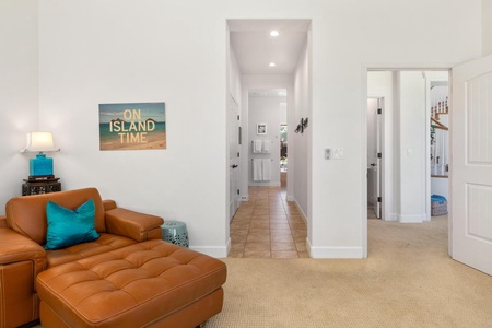 - Follow the bright tiled hallway connecting the bedroom to the main space - Playful “On Island Time” artwork sets the tone for your stay - Soft carpeting and leather chaise create a tranquil lounging corner