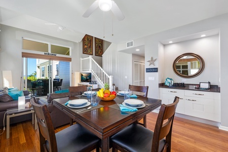 - Set for a fresh meal, this dark wood dining table seats four in elegant comfort - Positioned between kitchen and lounge for effortless entertaining and flow - Pops of turquoise and fruit accents add a lively tropical island vibe
