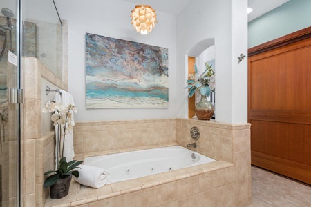 - Spa style bathtub surrounded by tile with coastal artwork above - Elegant pendant light and decorative touches add a relaxing ambiance - Ideal for unwinding after a day of exploring the island
