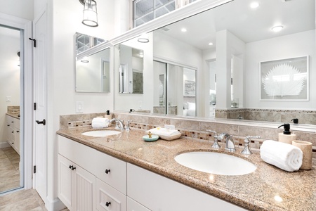 Ensuite primary bathroom with double vanity, walk-in shower, and soaking tub