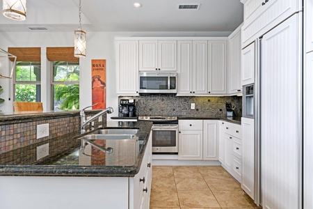 Full kitchen with breakfast bar, granite counters, and modern appliances