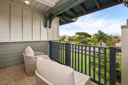 Unwind on your private balcony with comfortable seating, overlooking lush tropical gardens and distant mountains in this peaceful Hawaiian setting.