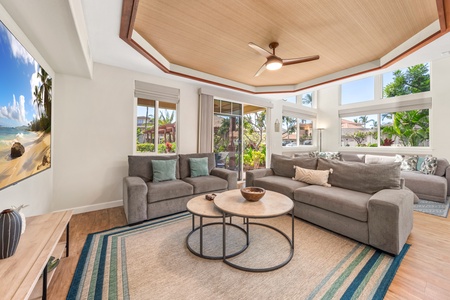 Unwind in your bright, tropical living room with panoramic windows showcasing lush garden views and comfortable seating for relaxing after your island adventures.