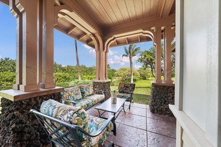 Unwind on your private covered patio with tropical garden views. Stone columns and comfortable seating create the perfect spot for morning coffee.