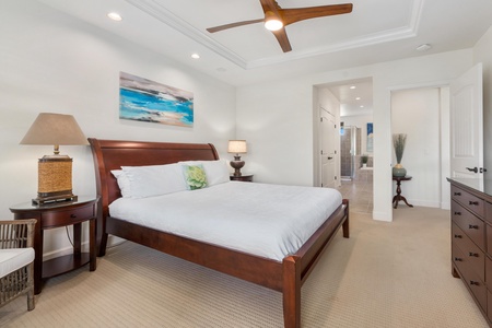 Unwind in your serene bedroom featuring a plush king bed, coastal artwork, and elegant wood furnishings that create the perfect retreat.