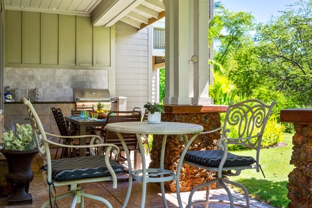 Covered lanai with garden views, dining table, and BBQ
