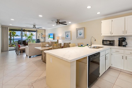 - Crisp white countertops and black appliances highlight this modern kitchen - Open layout flows to the living and dining space for easy entertaining - Island setup provides space for drinks, snacks, or casual meals anytime