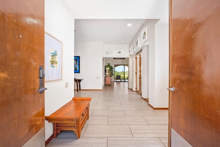 - Warm wood tones and tile flooring welcome you into a bright and airy hallway - Built in bench with storage provides a cozy and practical entry seating area - Straight sightline through the home reveals the scenic outdoor view ahead