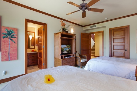 - Spacious bedroom with two queen beds and direct access to a private ensuite   - Wooden entertainment center with TV adds comfort and convenience for guests   - Ceiling fan and natural light create an airy, inviting atmosphere for rest