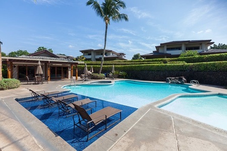 Resort style pool with lounge chairs and shaded umbrellas.