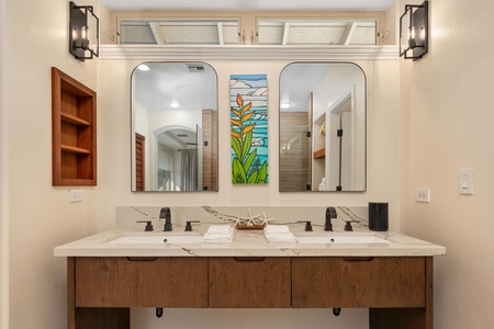 Start your mornings at this beautifully appointed double vanity, where warm wood tones and colorful tropical art create your perfect getting-ready space.
