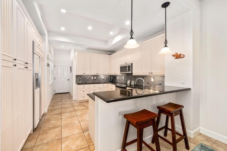 - Pull up a stool and enjoy casual bites at the breakfast bar for two - Elegant pendant lights and wide counter space complete the vibe - Easy access to the kitchen, hallway, and all parts of the home from here