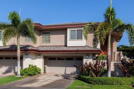 Modern two story home surrounded by beautiful tropical landscaping.
