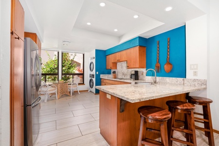 - Bold turquoise accent wall adds island flair to this fully equipped kitchen - Essential appliances and granite counters combine style and convenience - Enjoy a morning coffee at the bar or admire the greenery through oversized windows