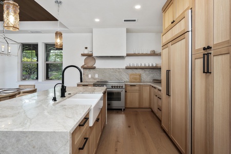 Step into your dream kitchen with warm wood cabinetry, marble countertops, and modern appliances where culinary adventures await.