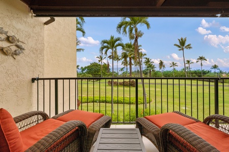 - Gaze across the lawn to swaying palms and distant ocean horizons from this lanai - Orange cushions and a side table create a perfect place to kick back and unwind - Covered outdoor seating lets you enjoy island views rain or shine
