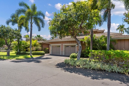 Beautiful tropical property surrounded by mature palm trees and lush landscaping with convenient parking access.