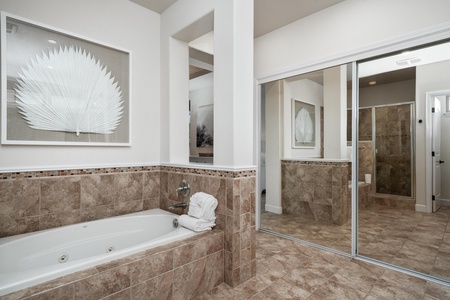 Your spacious spa-like bathroom features a marble jacuzzi tub and separate glass shower, perfect for unwinding after your adventures.