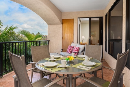 Savor your morning coffee on this private balcony, where tropical palm views and comfortable outdoor seating create the perfect breakfast retreat.