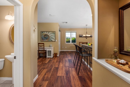 Step into your inviting open-plan space where warm wood floors connect the dining area to a bright breakfast nook with garden views—perfect for morning coffee or family meals.