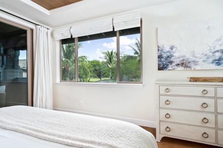 Wake up to tropical palm views from your serene bedroom, where coastal artwork and elegant furnishings create your perfect island retreat.