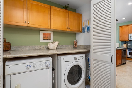 - Laundry area with washer, dryer, and overhead cabinetry for storage - Granite countertop offers space for folding clothes with ease - Conveniently located for guest use during longer stays