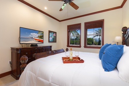 - Cozy bedroom with large windows offering beautiful tropical views   - Wall mounted TV provides easy entertainment from the bed   - Decorative tray with wine and glasses adds a touch of style