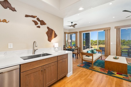 - Compact wet bar with wood cabinetry and marble countertop offering extra prep space - Unique wall art adds a local touch while framing views of the living and dining areas - Warm wood flooring continues seamlessly into bright indoor and outdoor spaces