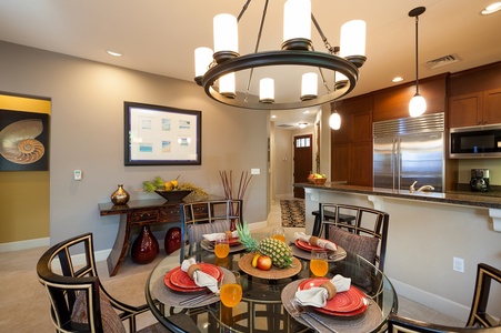 - Tropical inspired dining room with circular glass top table and seating for four - Pineapple centerpiece, fresh decor, and pendant lighting set a festive tone - Perfect for breakfasts, sunset dinners, or entertaining island style