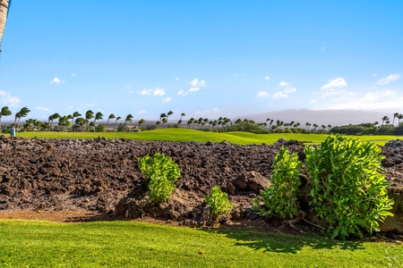 Beautiful fairway bordered by rugged lava rock and greenery.