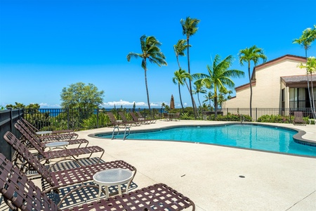 Lounge chairs set by the sunny pool.