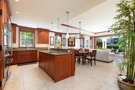 - Spacious kitchen with rich wood cabinetry, large island, and modern lighting   - Open layout connects seamlessly to dining and living areas   - Perfect for cooking and hosting in a bright, inviting environment