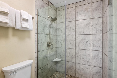 - Refresh in a walk in shower with floor to ceiling tile and stone pebble flooring - Built in shelf and rain style showerhead complete your tropical rinse experience - Glass door keeps things sleek while letting light fill the space