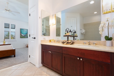 - Elegant vanity with double sinks and wide mirrors perfect for couples or families - Dark wood cabinetry adds contrast to the bright and airy bathroom - Soft lighting and thoughtful details make this space stylish and practical