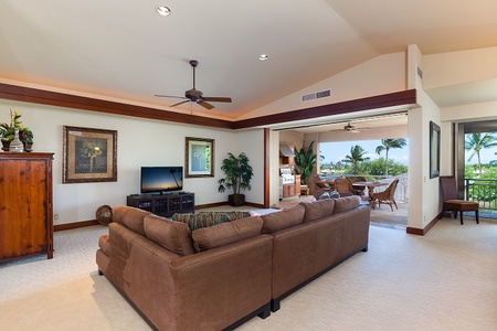 - Stylish living room with large sectional facing flat screen TV   - Ceiling fan and open flow to lanai create breezy indoor outdoor living   - Elegant décor blends tropical accents with a comfortable atmosphere