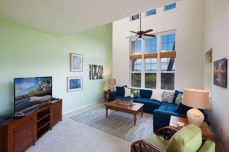 - Double height ceilings and tall windows bring in tons of natural light to this stylish living space - Comfortable sectional sofa and tropical wood furniture invite you to relax - Wall mounted TV and soft carpet complete the cozy entertainment vibe