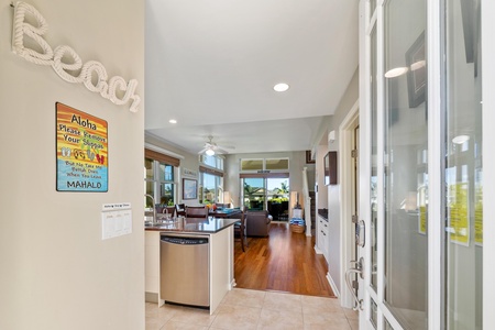 - Step inside to a bright open concept home with wood floors and tropical flair - From the front door, see straight through to the beautiful outdoor patio beyond - Kitchen island, dining table, and living room are all within easy reach