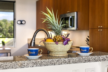 - Close up of kitchen counter with tropical fruit arrangement centerpiece   - Adds a colorful and fresh touch to the modern kitchen decor   - Perfect spot for enjoying morning coffee or casual afternoon snacks