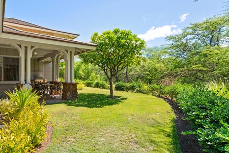 Covered lanai with garden views, dining table, and BBQ