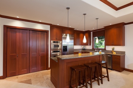 - Stylish kitchen with rich wood cabinetry and granite island breakfast bar   - Stainless steel appliances and pendant lights enhance the upscale feel   - Perfect for preparing meals or enjoying casual drinks with friends