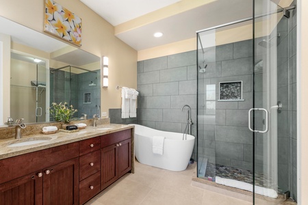 Remodeled primary bathroom with double vanity, walk-in shower, and soaking tub
