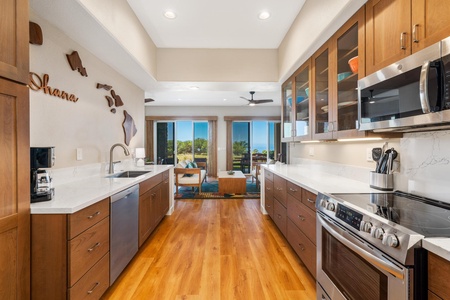 - Galley style kitchen with warm wood cabinetry & pristine white countertops - Fully equipped with stainless steel appliances and extra storage for cooking essentials - Open view leads directly to living area with sliding doors to scenic outdoor spaces