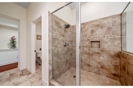 Ensuite primary bathroom with double vanity, walk-in shower, and soaking tub